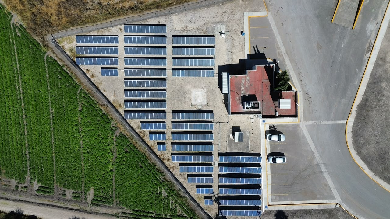 Módulos fotovoltaicos instalados sobre terreno junto a una instalación agroindustrial